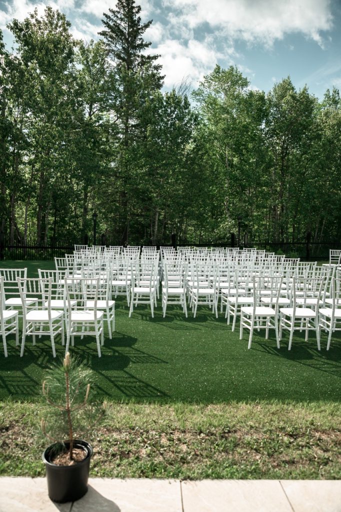 White chairs arranged in rows on a greenspace